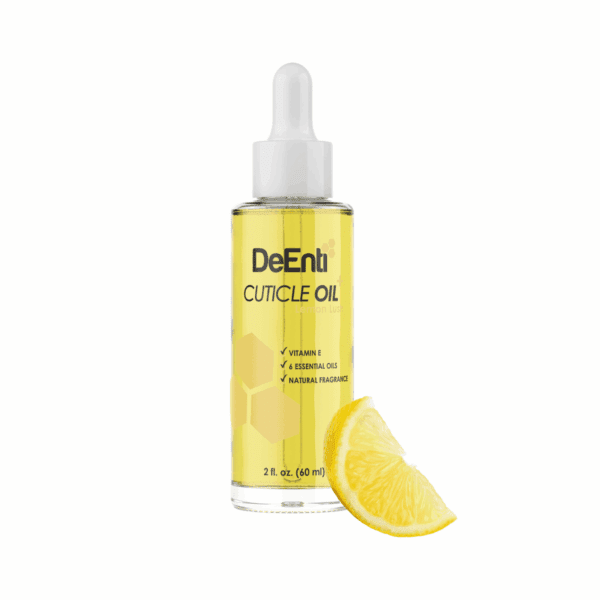 A 2 fl oz glass dropper bottle of DeEnti Lemon Lush Cuticle Oil resting next to a fresh, bright lemon wedge on a white background.
